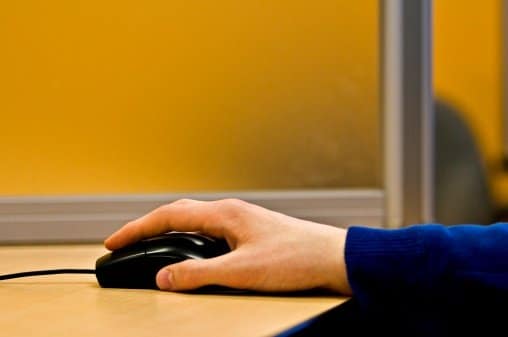 Man's hand on a computer mouse.