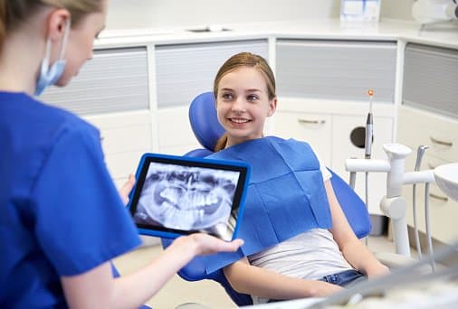 dentist with x-ray on tablet pc and patient