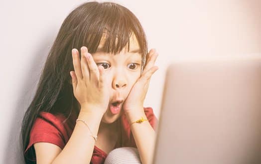 Girl surprised while looking at computer