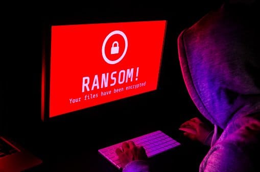 Man looking at screen that says Ransom your files have been encrypted