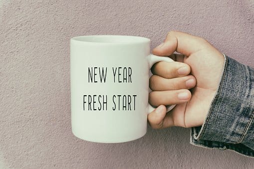 Hand Holding a Coffee Mug With Text New Year Fresh Start