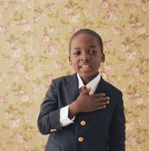 Boy holding hand to chest, portrait