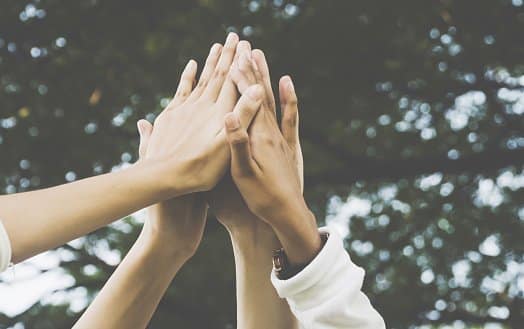 Four people giving high fives